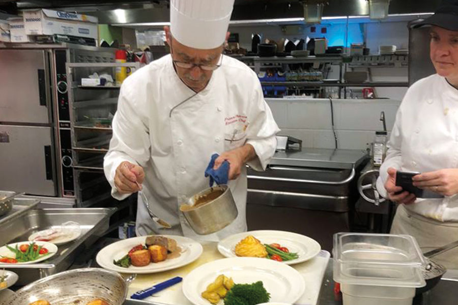 Chef Franco Paterno preparing a tasting meal in front of students. 