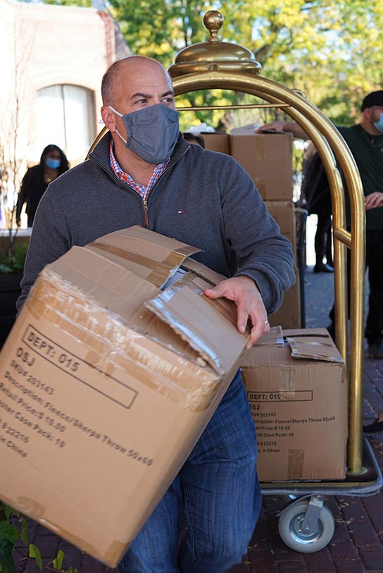 Paul Conforti, Chief Marketing Officer, Ocean State Job Lot, grabs a box of blankets to load into a waiting vehicle. 