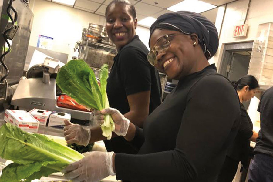 Students working in the kitchen preparing lettuce