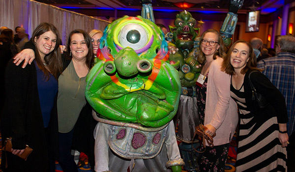Attendees posing with the alien character